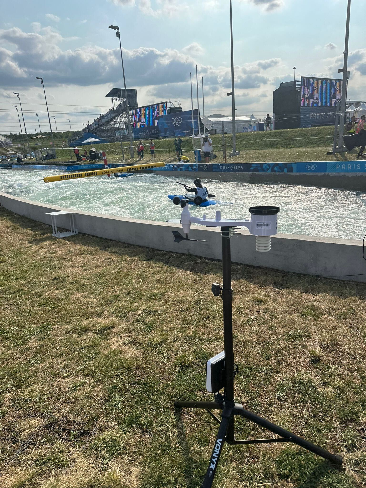 WeatherXM weather station on tripod next to whitewater canoe slalom rapids at Paris 2024